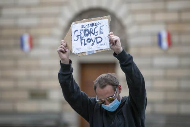 Demonstrators take part in the Take A Knee for George Floyd solidarity protest organised by Stand Up To Racism Scotland, outside St Giles' Cathedral in Edinburgh in memory of George Floyd