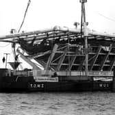 The Mary Rose in its cradle being brought ashore by a barge in October 1982. The News PP3741