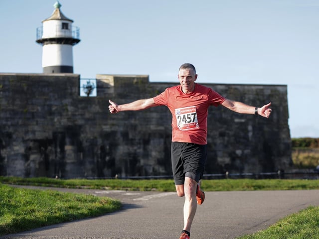 A runner celebrates getting to the end of the course. Picture: Chris  Moorhouse (221224-89)