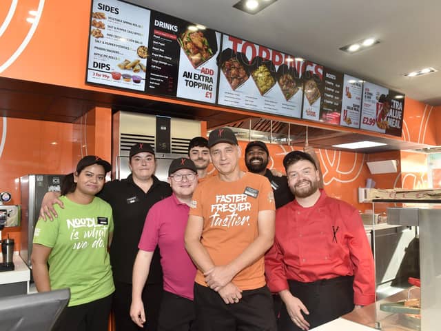 Pictured is: (front in orange) Darren Godfrey, Chopstix Noodle Bar Portsmouth franchisee, with some of the team. Picture: Sarah Standing (170924-1554)