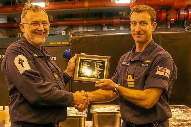 Alan ‘Sharkey’ Ward pictured with Commander Charlie Wheen as he receives an award for spending 5,000 days at sea with the Royal Navy