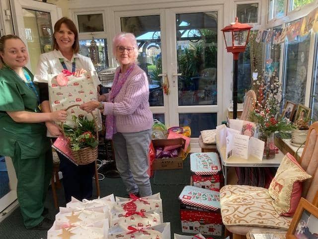Thelma handing over the gifts to Jenna and Emma of The Orchards unit