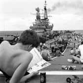 Taking it easy from the rigours of training, men aboard the HMS Hermes take time out for a little sunbathing on the carrier's flight deck as she heads south with the British naval task force for the Falklands.