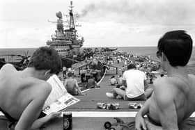 Taking it easy from the rigours of training, men aboard the HMS Hermes take time out for a little sunbathing on the carrier's flight deck as she heads south with the British naval task force for the Falklands.