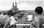 Taking it easy from the rigours of training, men aboard the HMS Hermes take time out for a little sunbathing on the carrier's flight deck as she heads south with the British naval task force for the Falklands.