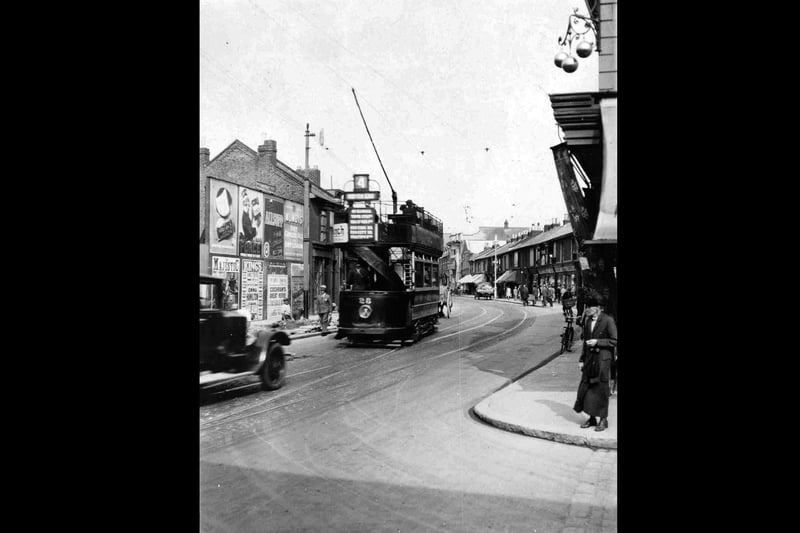 A scene from Portsmouth in the late 1920s, showing a tramcar heading down Kingston Road, taken from the corner of Toronto Road. Top right can be seen the three balls of the local pawn shop. The hoarding to the left advertises the Majestic Cinema which is in the centre of the photo in front of the tram. It is now a bingo hall.