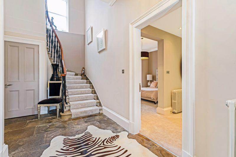 The main hallway has flagstone flooring and two storage cupboards.