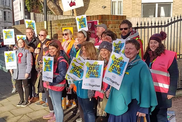 Teachers hold placards as they go on strike.