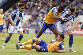 Former Pompey player and current Mansfield defender Callum Johnson is grounded as team-mate Lucas Akins and two Colchester opponents battle for possession in Sunday's heartbreaking finale. Picture: Steven Paston/PA Wire.