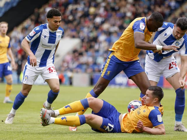 Former Pompey player and current Mansfield defender Callum Johnson is grounded as team-mate Lucas Akins and two Colchester opponents battle for possession in Sunday's heartbreaking finale. Picture: Steven Paston/PA Wire.