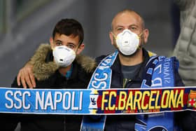 Fans wear medical face masks as they await kick off prior to the UEFA Champions League tie between SSC Napoli and FC Barcelona in Naples recently. Photo by Michael Steele/Getty Images.