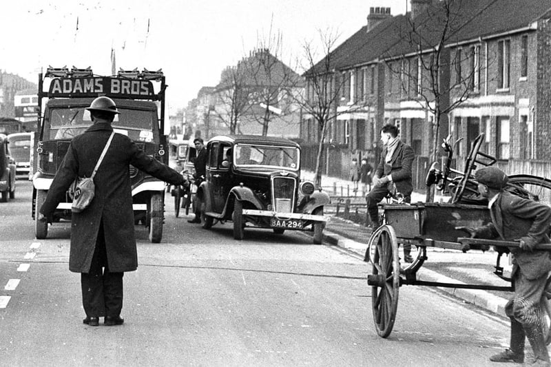 An Air Raid Precaution warden brings traffic to a halt in Copnor Road, Copnor, Portsmouth, in February 1940