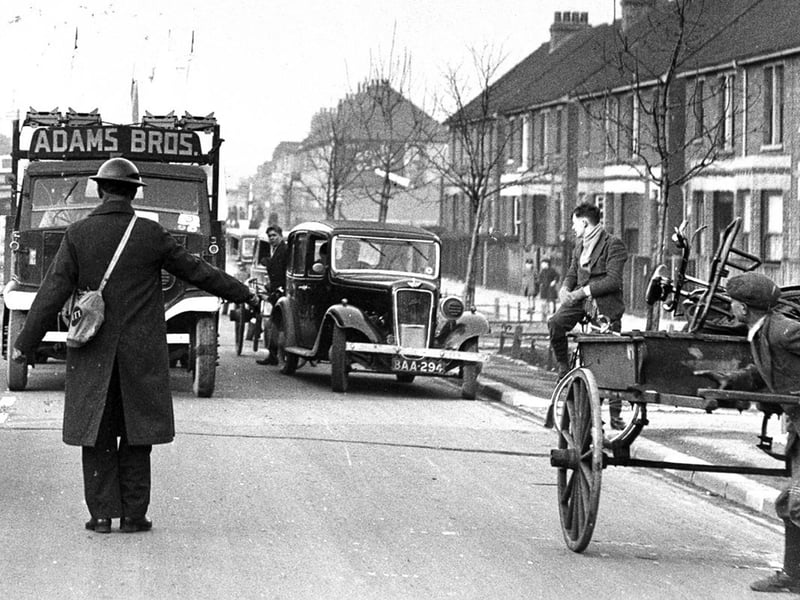 An Air Raid Precaution warden brings traffic to a halt in Copnor Road, Copnor, Portsmouth, in February 1940