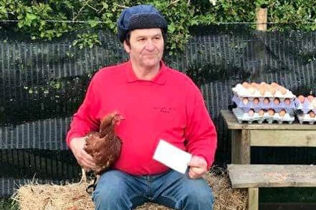 Farmer Richard Small with the cheque for £1,200 from the Drayton community and one of his chickens.
