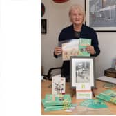Fiona Ballard with her book Taking the Bandage, childhood drawings and photograph of her in hospital as a baby 
Picture: Keith Woodland (301021-2)