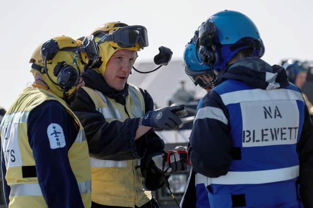 Crew on the deck of HMS Queen Elizabeth after the new Wildcat Commando helicopter landed on the ship. Photo: Royal Navy