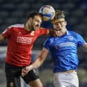 Sean Raggett of Portsmouth heads the ball under pressure from, Brett Pitman of Swindon Town during the EFL Sky Bet League 1 match between Portsmouth and Swindon Town at Fratton Park, Portsmouth, England on 9 February 2021.