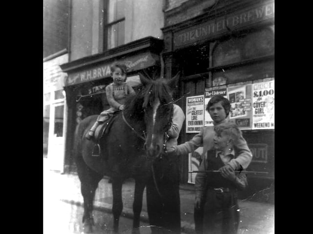 Lee Bryant on a pony outside his grandfather's paper shop WH Bryant's in Charlotte Street, Portsmouth