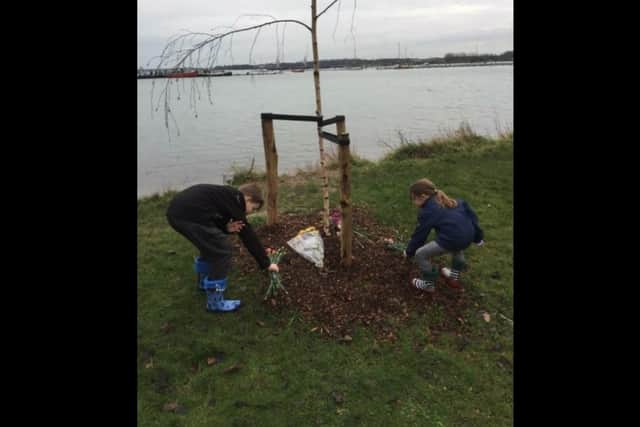 Two of Bell Cook's grandchildren leaving flowers at the memorial tree. Picture: Kyla Smith.