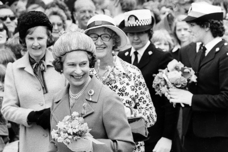 The Queen was given so many posies that a policewoman was needed to help carry them to the royal car, 1980. The News PP5126