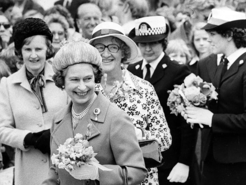 The Queen was given so many posies that a policewoman was needed to help carry them to the royal car, 1980. The News PP5126