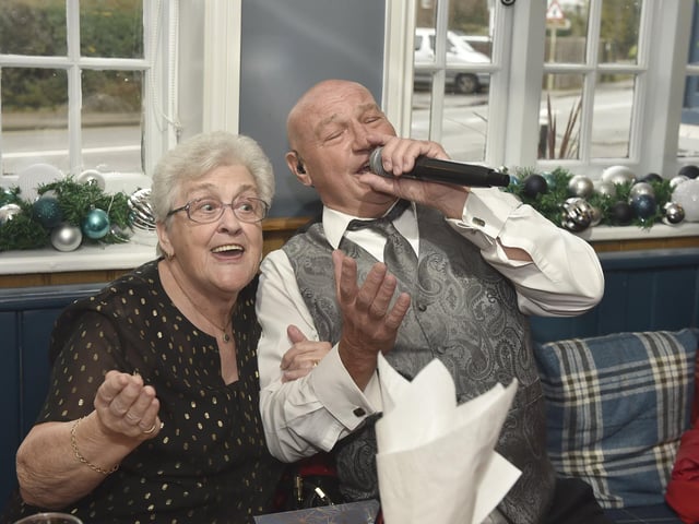 The annual Christmas lunch for OAPs at the White Hart pub in Denmead on Tuesday, December 5, 2023.Pictured is: Pam Baker (79) from Denmead, sings with Malc De Reding.Picture: Sarah Standing (051223-3157)