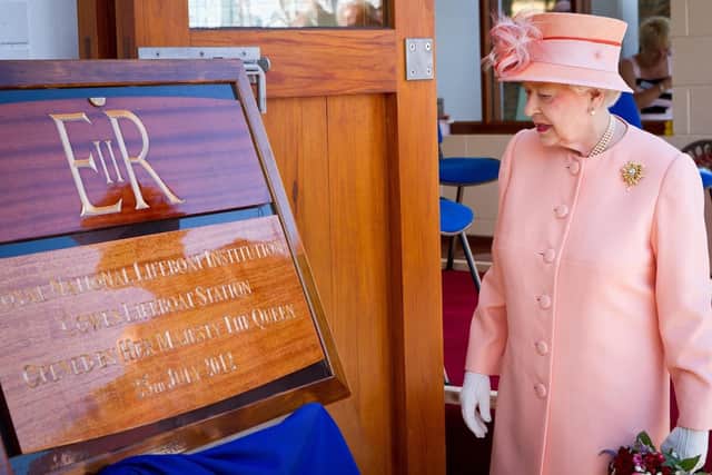 The Queen admires the commemorative board: Credit: RNLI Cowes
