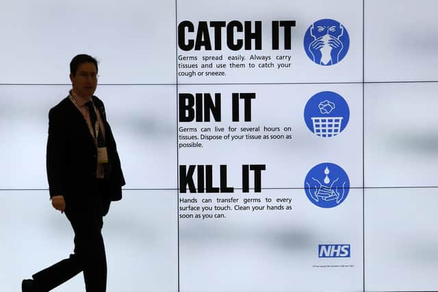 An NHS catch it, bin it, kill it sign on TV screens in the entrance to the QEII Centre in London. Picture: Philip Toscano/PA Wire