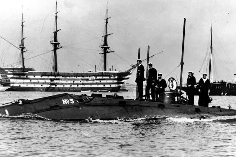 An early submarine (Holland 3) in Portsmouth Harbour, with HMS Victory behind, 1905.