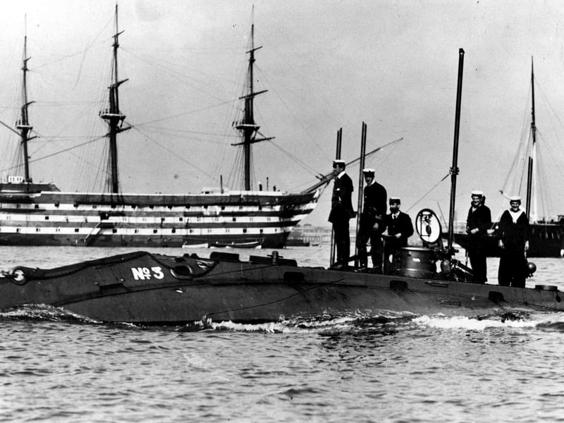 An early submarine (Holland 3) in Portsmouth Harbour, with HMS Victory behind, 1905.