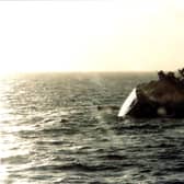 The British destroyer HMS Coventry sinks after being hit by bombs from Argentine Skyhawk aircraft on May 25, 1982