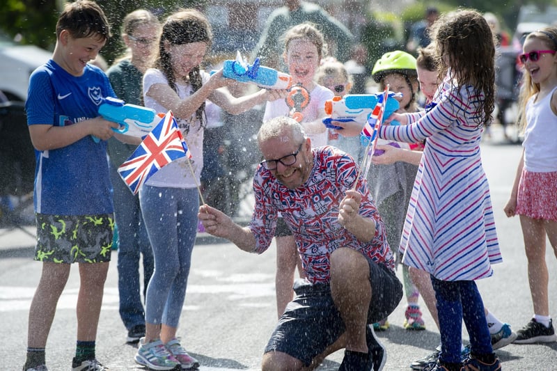 Allan Gingell from First Avenue, Drayton is squirted with water during the street party