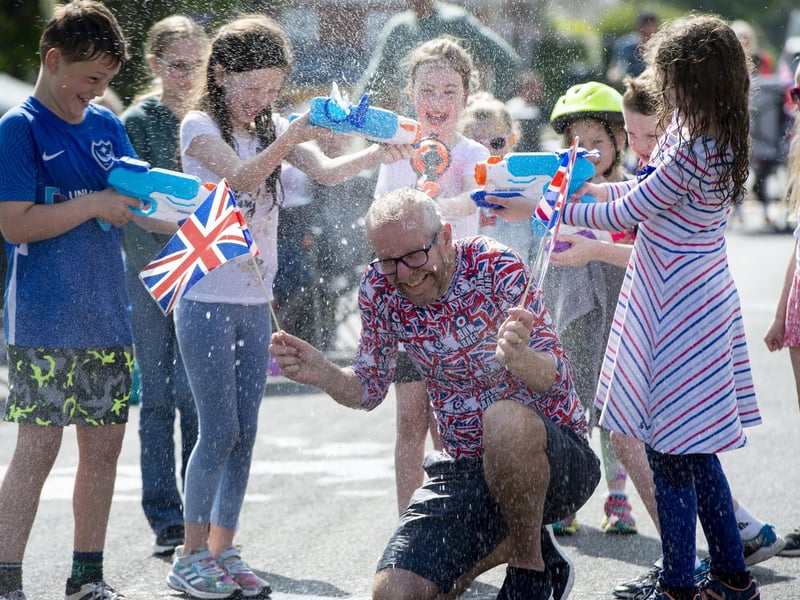 Allan Gingell from First Avenue, Drayton is squirted with water during the street party