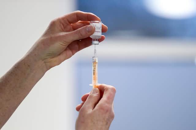 A healthcare worker fills a syringe with a dose of the Oxford/AstraZeneca coronavirus vaccine. Picture: PA.