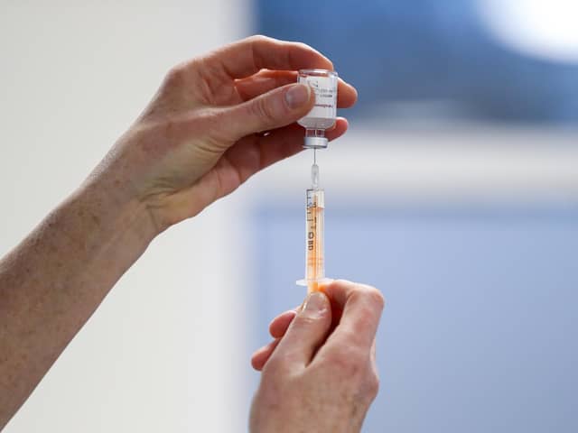 A healthcare worker fills a syringe with a dose of the Oxford/AstraZeneca coronavirus vaccine. Picture: PA.