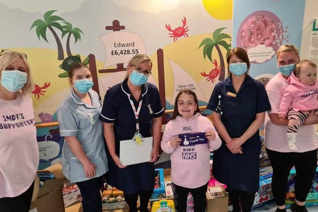 India-Rose Jenkins, 6 from Hilsea, delivered toys and chocolates to Queen Alexandra Hospital after raising £1,200 through a walking challenge. Pictured: India-Rose handing over the donations to staff from Starfish ward, accompanied by nanny Pauline Jenkins, mum Chantelle Jenkins and little sister Sofia-Mae