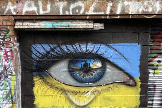 The new My Dog Sighs mural in Northcote Lane, Cardiff of a weeping eye in the colours of the Ukrainian flag.