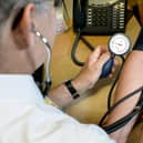 A GP takes a patient's blood pressure