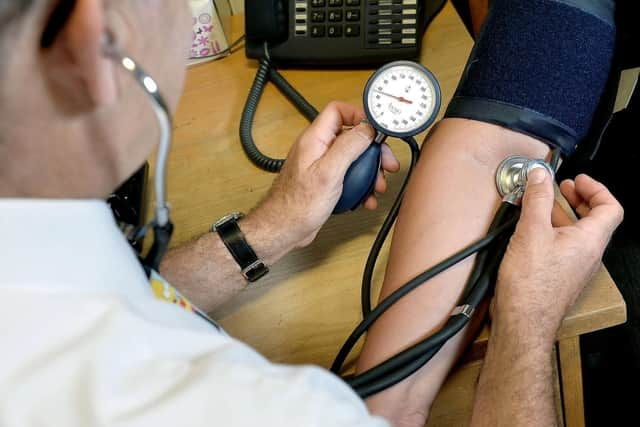 A GP takes a patient's blood pressure