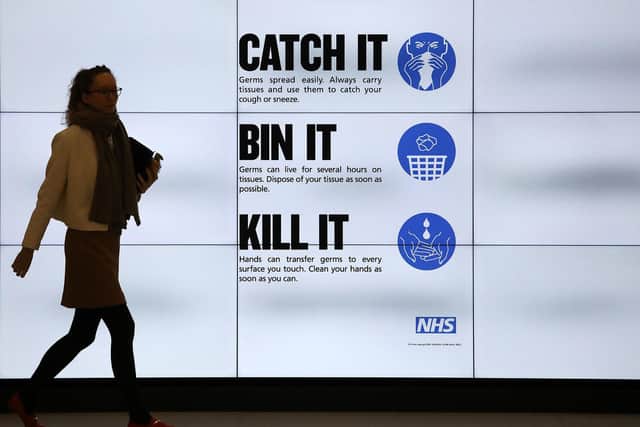 An NHS catch it, bin it, kill it sign on TV screens in the entrance to the QEII Centre in London. Picture: Philip Toscano/PA Wire