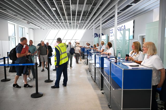 Passengers check in at the arrival desks in the new terminal