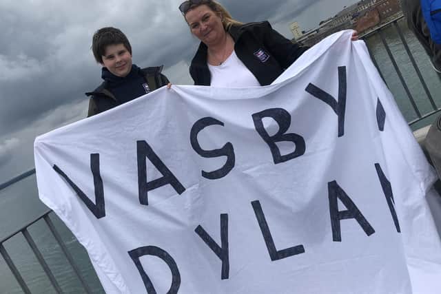 Carolann Hemy with her son Adam, 12, holding a banner.