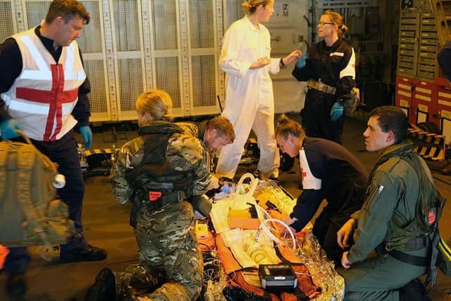 Medics tend to the casualty in HMS Richmond's hangar.
