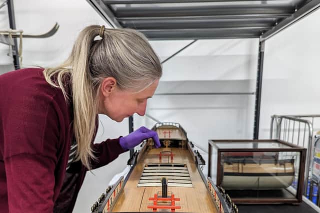 The model is inspected by Principal Curator Victoria Ingles before going on display on Saturday 21 October 2023.