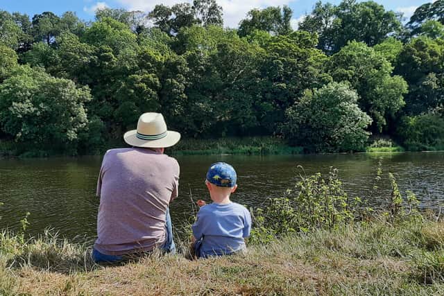 Grandpa and Grandson take a moment to enjoy the river. River Trent, Nottinghamshire, UK. August