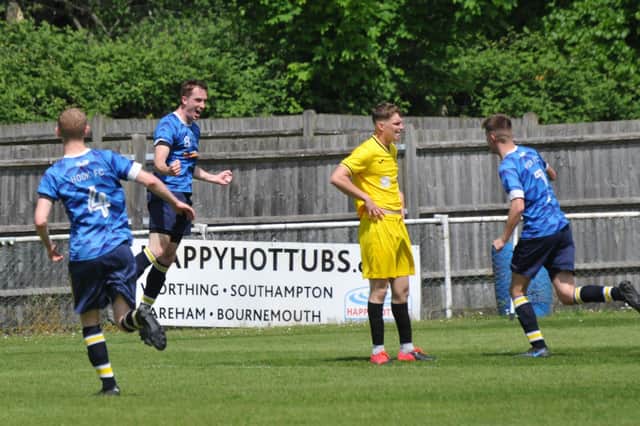A Harvest defender's body language says it all as Hook celebrate another goal. Picture by Ian Grainger.