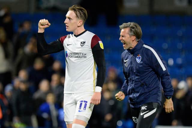 Ronan Curtis salutes the Pompey fans at Wycombe as assistant boss Nicky Cowley celebrates at the final whistle at Adams Park