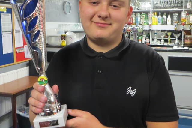 Samuel Laxton holds aloft his trophy