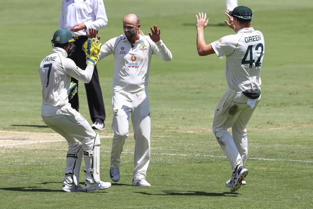 Nathan Lyon, centre, is congratulated by Tim Paine, left, and Cameron Green after taking the wicket of India's Shubman Gill during this week's Test at the Gabba, Brisbane. Pic: AP Photo/Tertius Pickard.