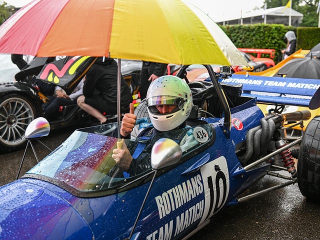 Drivers shield from the rain at the Goodwood Festival of Speed at Goodwood House in West Sussex. Picture date: Friday June 14, 2023. PA Photo. This year, the event celebrates its 30th anniversary and takes place from June 13-16. Picture credit should read: John Nguyen/PA Wire.